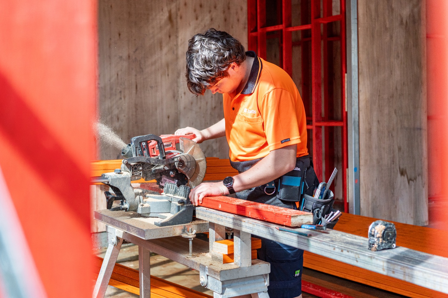 A carpenter making a cut inside the new timber frame