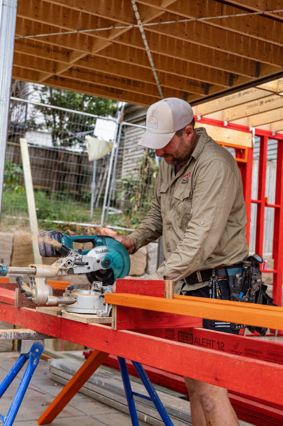 Cutting red framing timber at the saw bench
